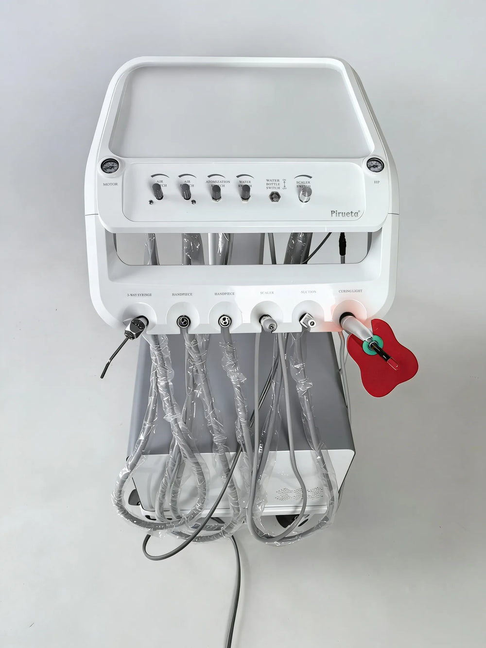Close-up of the PT-668D instrument tray showing adjustable control knobs for air and water, alongside slots for a 3-way syringe, scaler, and curing light